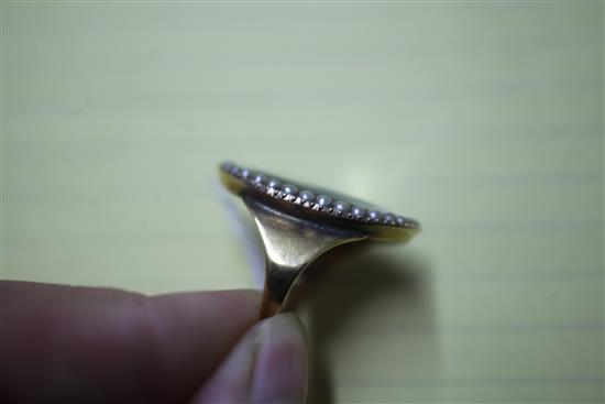 An early 20th century yellow metal and split pearl set portrait miniature ring (adapted), size V.